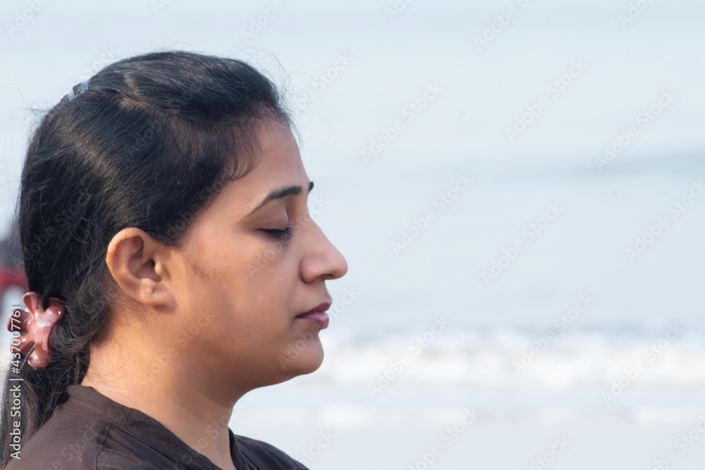 Woman meditating with eyes closed at beach Woman meditating with eyes closed at beach
