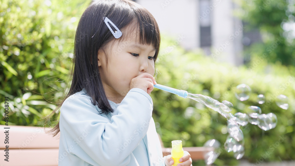 野外でしゃぼん玉で遊ぶ子供