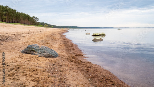 Sleeping stones by the calm sea, on a sunny summer evening. Peace and harmony by the Baltic Sea.