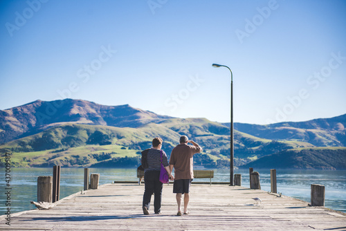 Couple walking on the dock, Akaroa, New Zealand