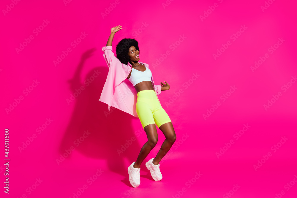 Photo of pretty adorable dark skin woman dressed crop top smiling dancing isolated pink color background Photo of pretty adorable dark skin woman dressed crop top smiling dancing isolated pink color background