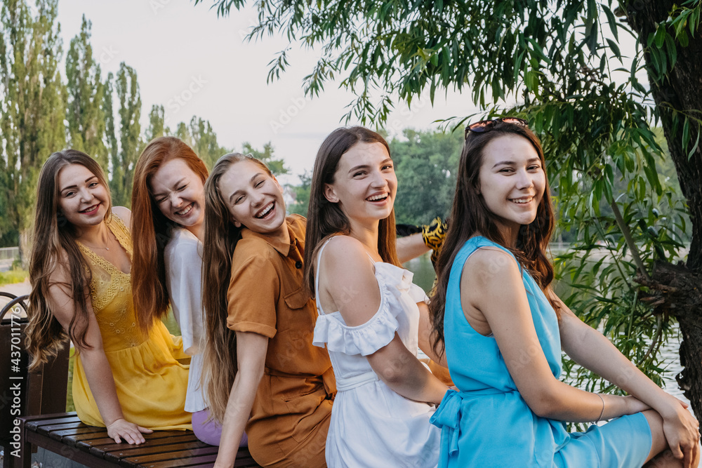 Group of happy young women, female friends having fun on summer nature background. Many young female friends together looking the sunset. Female Friendship and Forever friends concept Group of happy young women, female friends having fun on summer nature background. Many young female friends together looking the sunset. Female Friendship and Forever friends concept