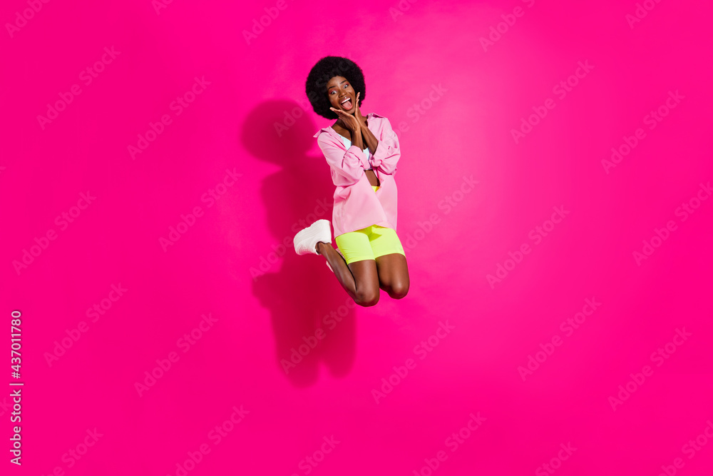 Full size photo of young excited african girl happy positive smile amazed surprised jump isolated over pink color background Full size photo of young excited african girl happy positive smile amazed surprised jump isolated over pink color background