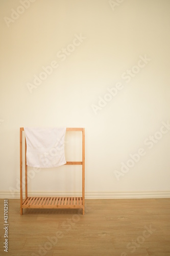 muji minimal with hanging white hand towel on wooden hanger background white and warm mood wallpaper