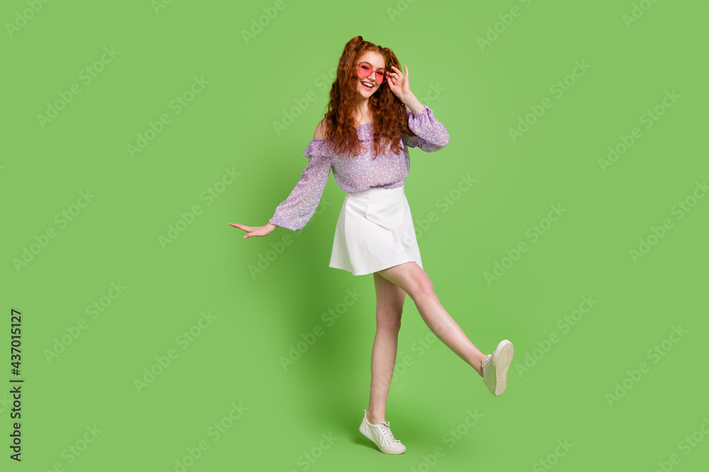 Full length photo of sweet red hairstyle young lady go wear blouse skirt spectacles isolated on green color background Full length photo of sweet red hairstyle young lady go wear blouse skirt spectacles isolated on green color background