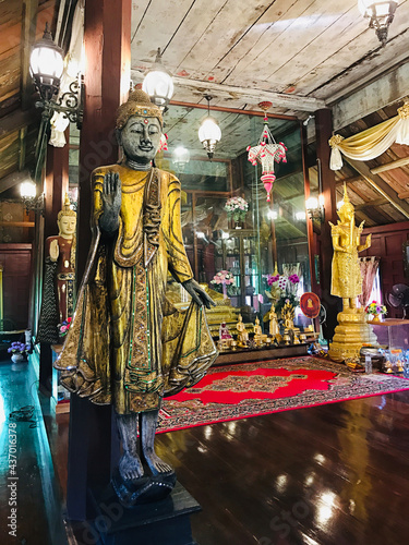 Trat, Thailand - December 20, 2020:  Wooden Buddha image in the wooden prayer hall of Buppharam temple (Wat Buppharam or Wat Plai Khlong) in Trat, Thailand. photo