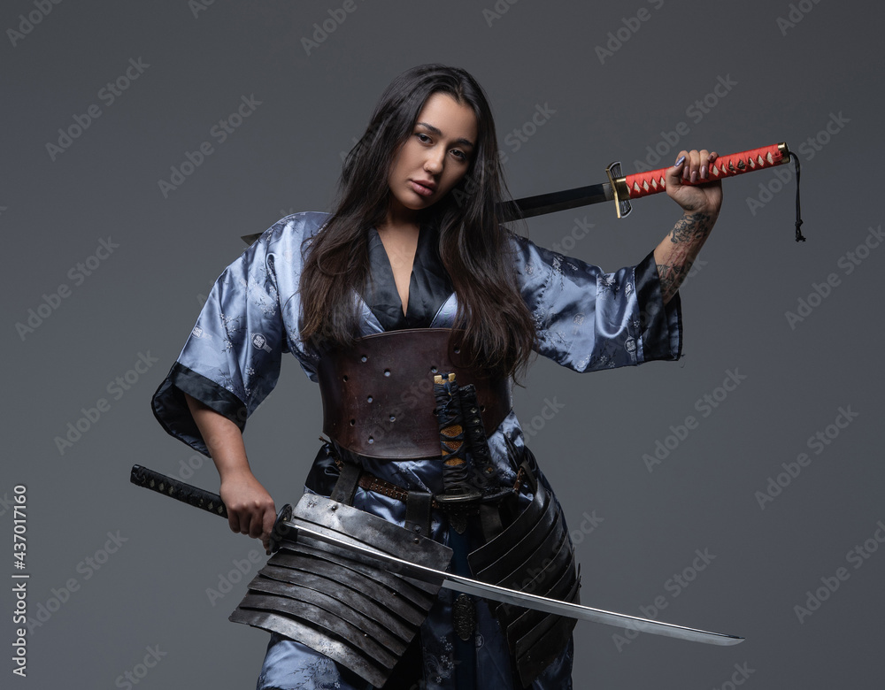 Dangerous woman samurai posing with samurai swords Photos Adobe Stock