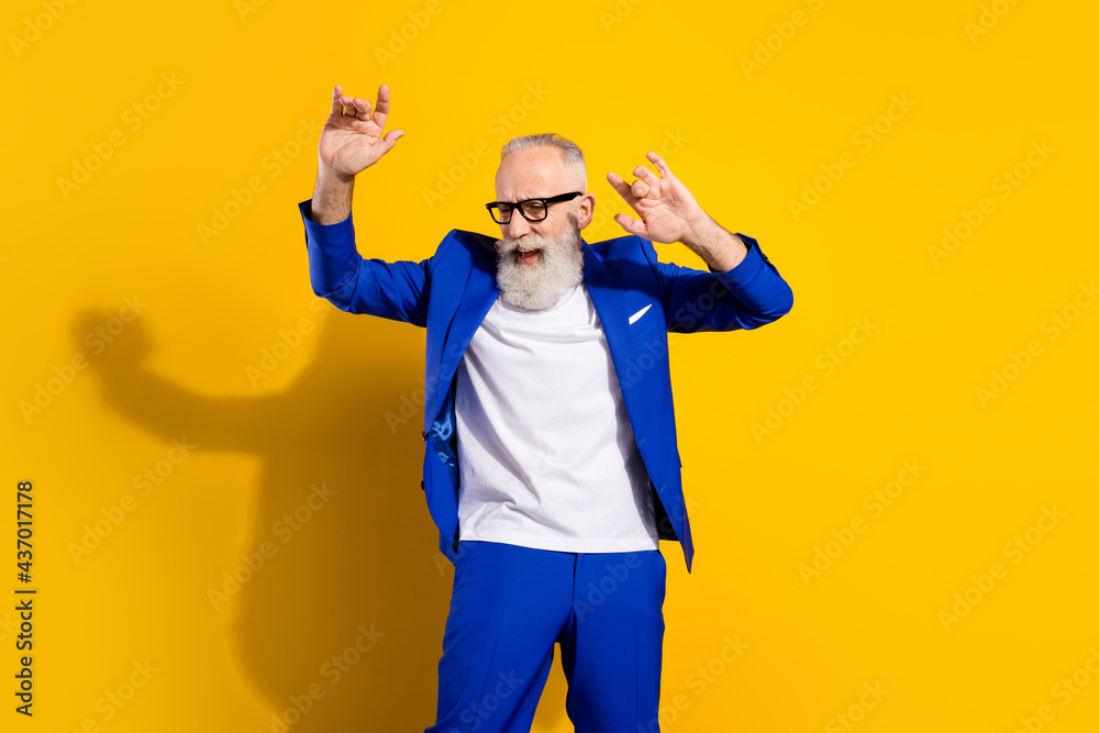 Photo portrait of businessman wearing blue suit spectacles cheerful dancing at party isolated on vibrant yellow color background