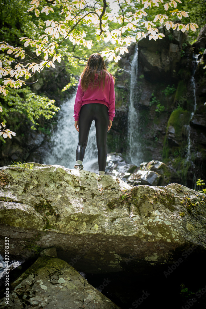 woman standing on a rock in the forest
