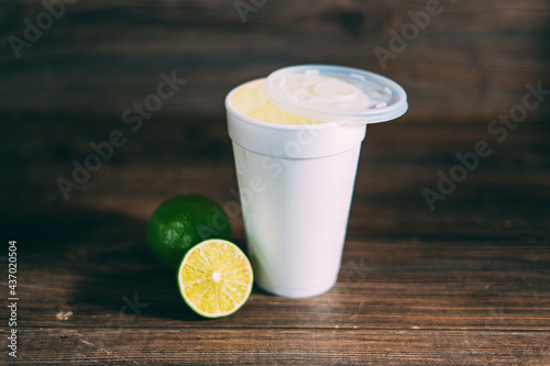 A styrofoam cup and a citrus fruit