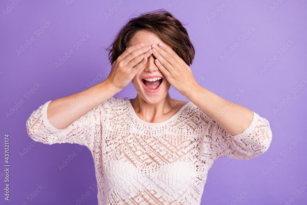 Photo of excited sweet young lady dressed white shirt arms cover face ready look for you isolated purple color background Photo of excited sweet young lady dressed white shirt arms cover face ready look for you isolated purple color background