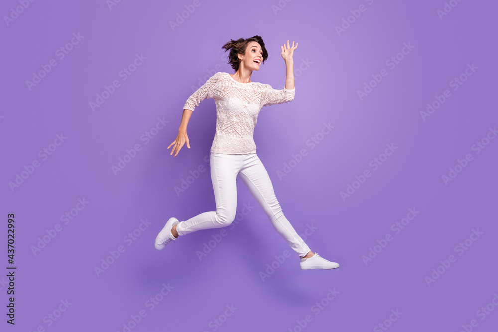 Full length photo of sweet pretty young woman wear knitted shirt jumping high isolated violet color background