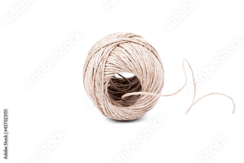 Twine on a white background. The coil of twine on the side is turned with an overturn in the center towards the viewer.