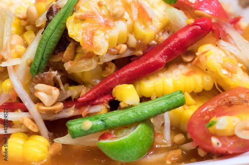 Corn cooked like Thai 's papaya salad in paper dish. Close up. photo