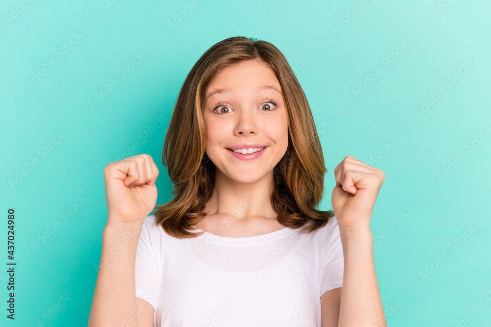 Photo portrait little girl happy gesturing like winner isolated vivid turquoise color background Photo portrait little girl happy gesturing like winner isolated vivid turquoise color background