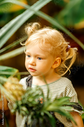 Wallpaper Mural close up Portrait of a cute adorable blonde Caucasian girl watching the plants grow in the greenhouse. The child is studying nature. Early development concept. Torontodigital.ca