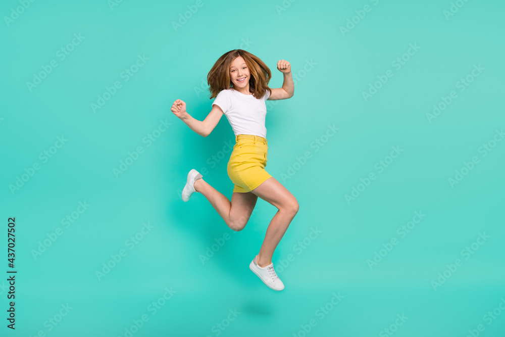 Full length body size photo schoolgirl jumping up gesturing like winner isolated vivid teal color background
