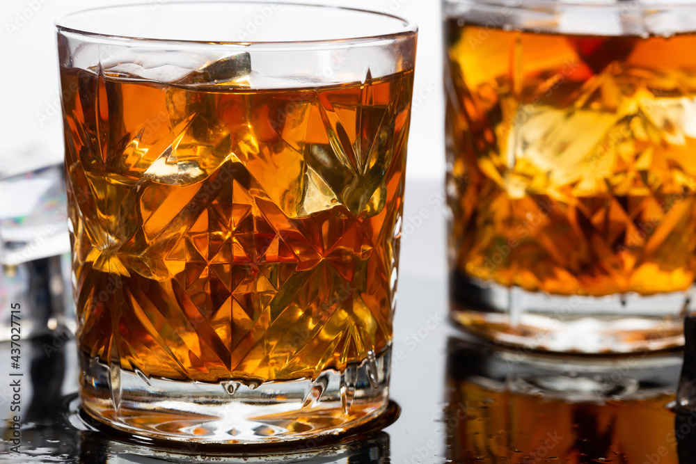 Whiskey in old fashioned glasses with ice, close up
