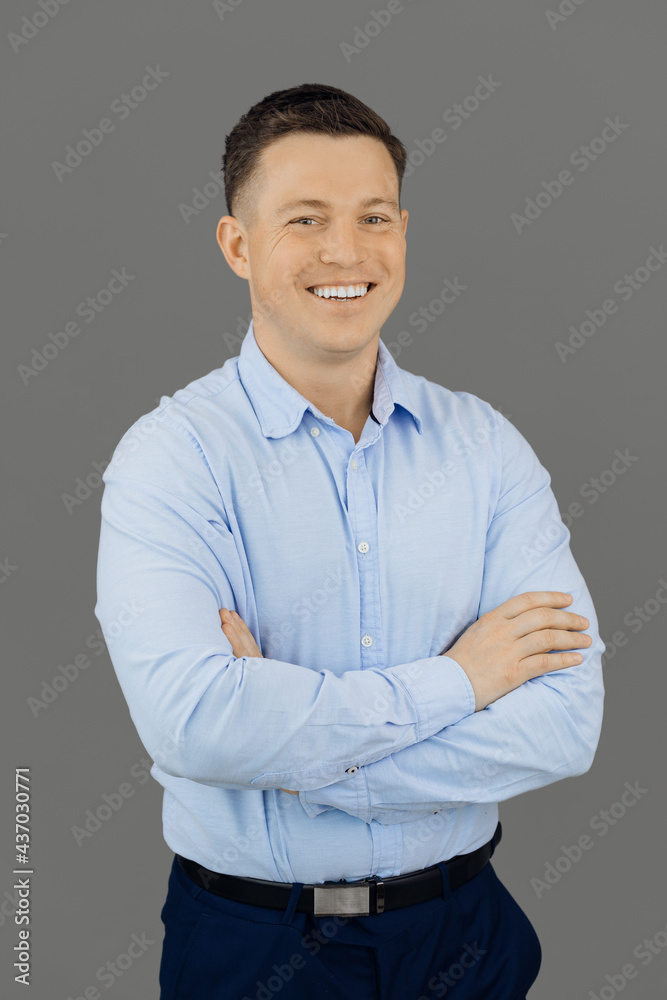 Handsome, smiling and self-sufficient man on gray background looks confidently at the camera. Online education concept Handsome, smiling and self-sufficient man on gray background looks confidently at the camera. Online education concept