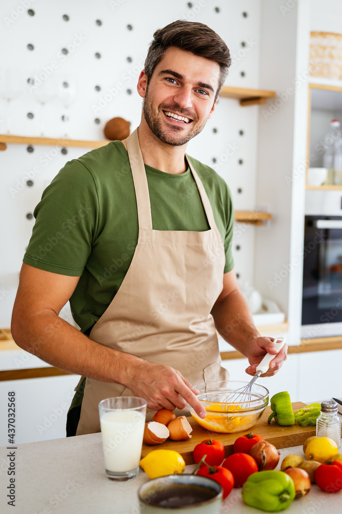 Cheerful young man preparing healthy food in the kitchen Cheerful young man preparing healthy food in the kitchen