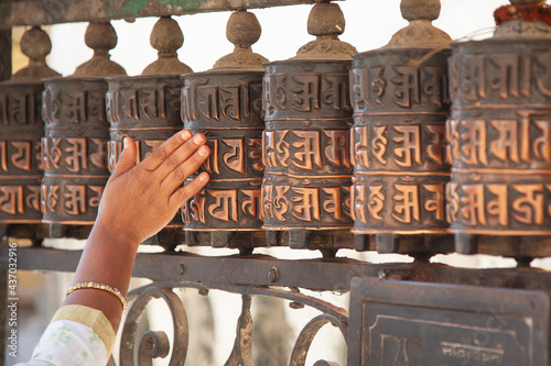 Fotografie Hand turning prayer wheels at the Swayambhunath Stupa in Kathmandu