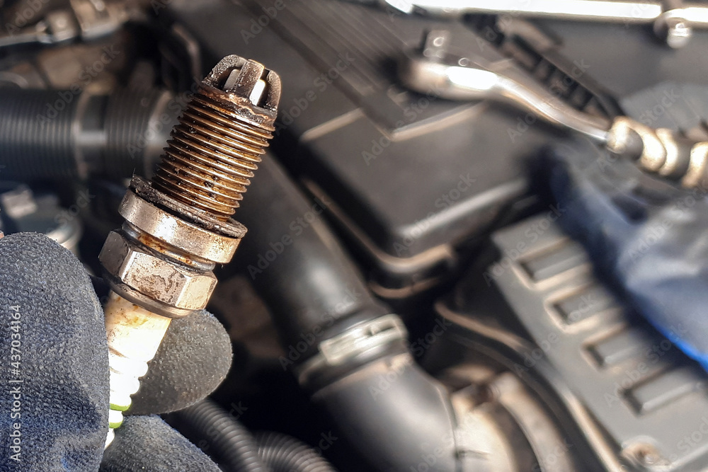 Old car candle on engine background in human hand. Mechanic concept. repair Old car candle on engine background in human hand. Mechanic concept. repair
