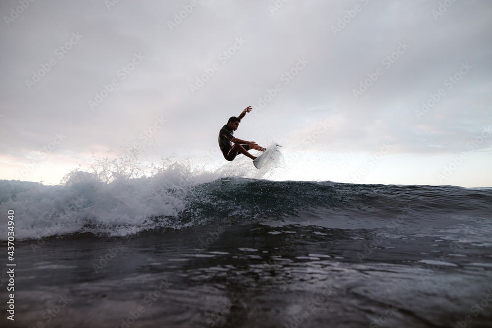 Athlete practicing surfing on ocean wave