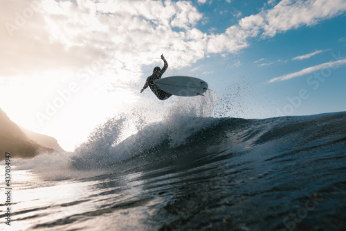 Unrecognizable athlete practicing surfing on ocean wave