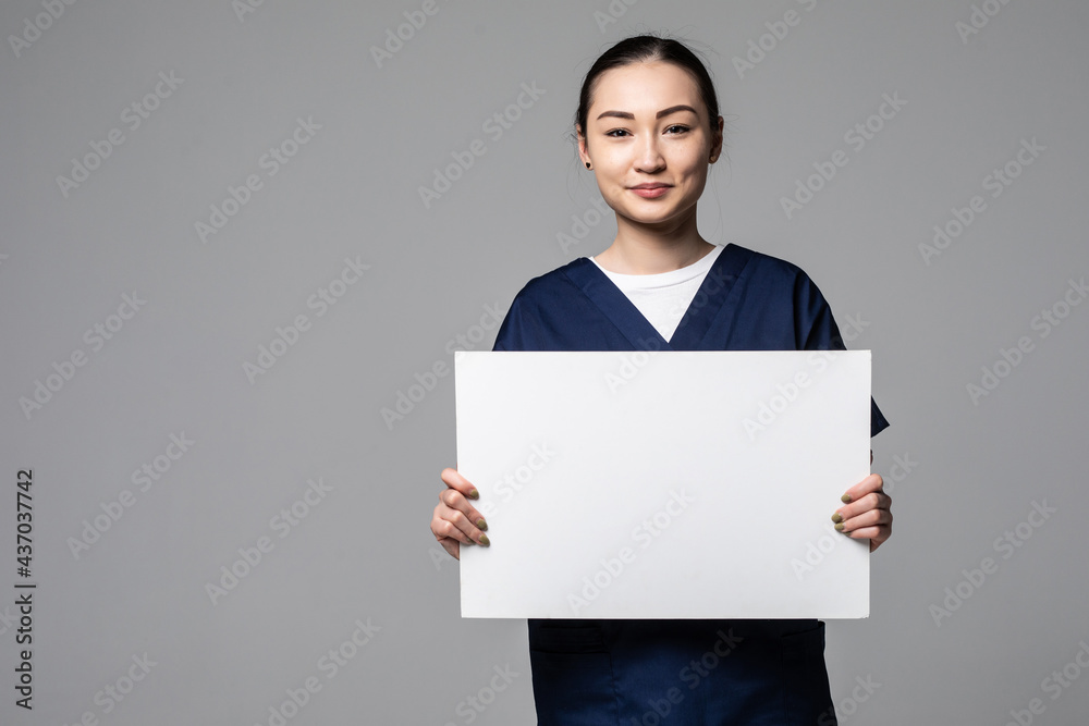 Young doctor woman showing blank billboard isolated on white background Young doctor woman showing blank billboard isolated on white background