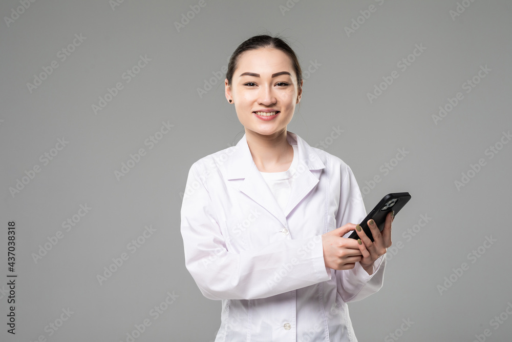 Young asian woman doctor using smart phone isolated on white background Young asian woman doctor using smart phone isolated on white background