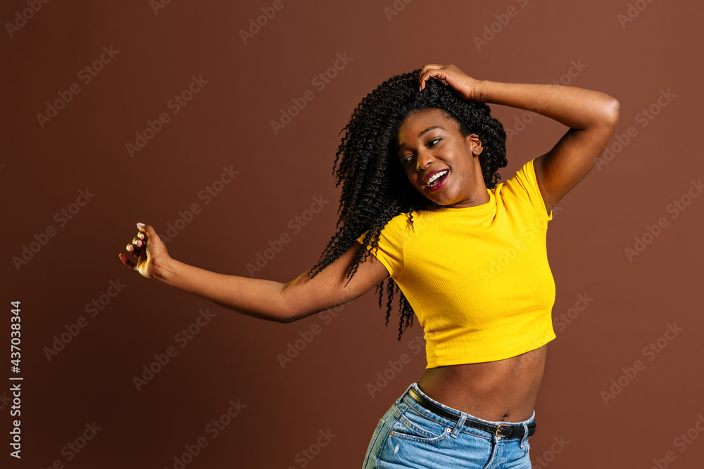 Smiling black woman raising hands while dancing Smiling black woman raising hands while dancing