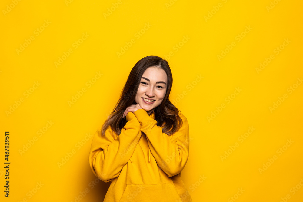 Asian woman shy isolated on yellow background in studio. Asian woman shy isolated on yellow background in studio.