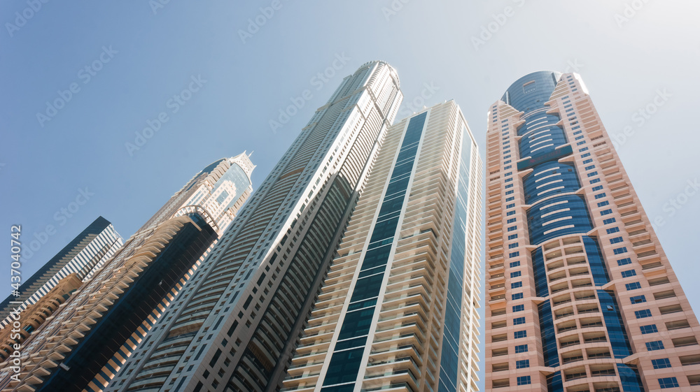 Modern skyscrapers in the city under the blue sky on a clear day. Dubai Marina district. Architectural, construction or travel concept. Fastly developing city in Middle East. High quality photo