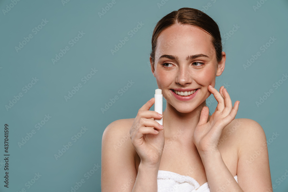 Young brown haired woman showing lip balm - obrazy, fototapety, plakaty 