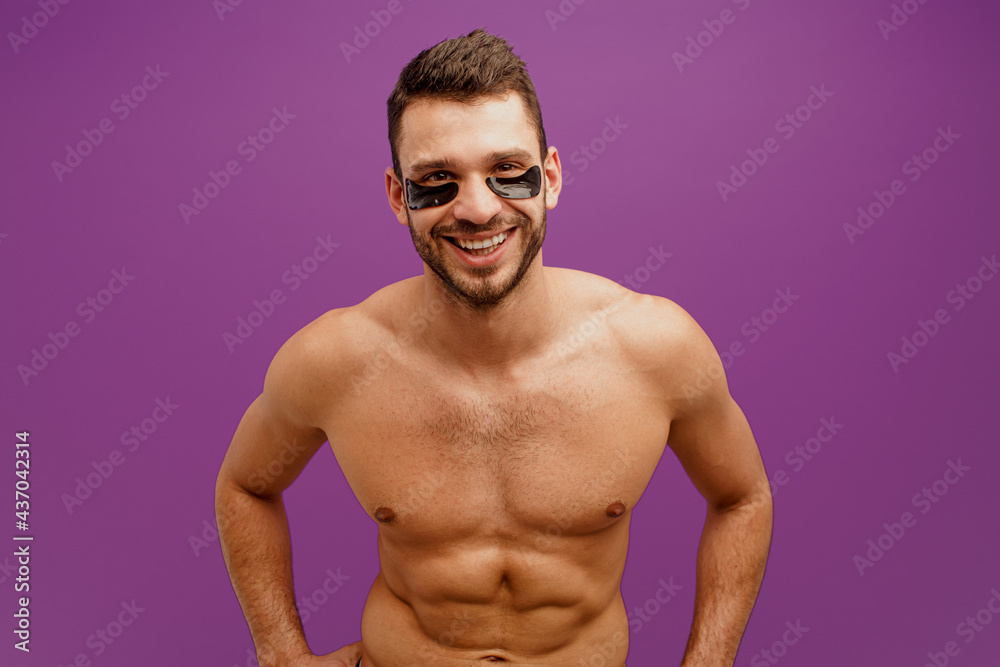 Smiling man with under eye patch on face Smiling man with under eye patch on face