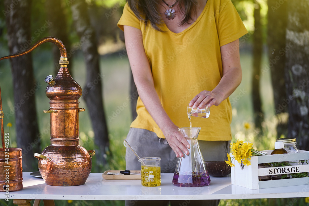 Wall Mural A woman's hands making essential oils at a work table in the field