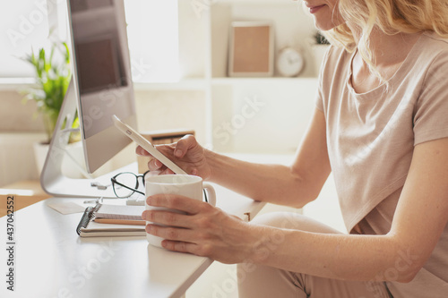 A young blonde girl works in a modern office.