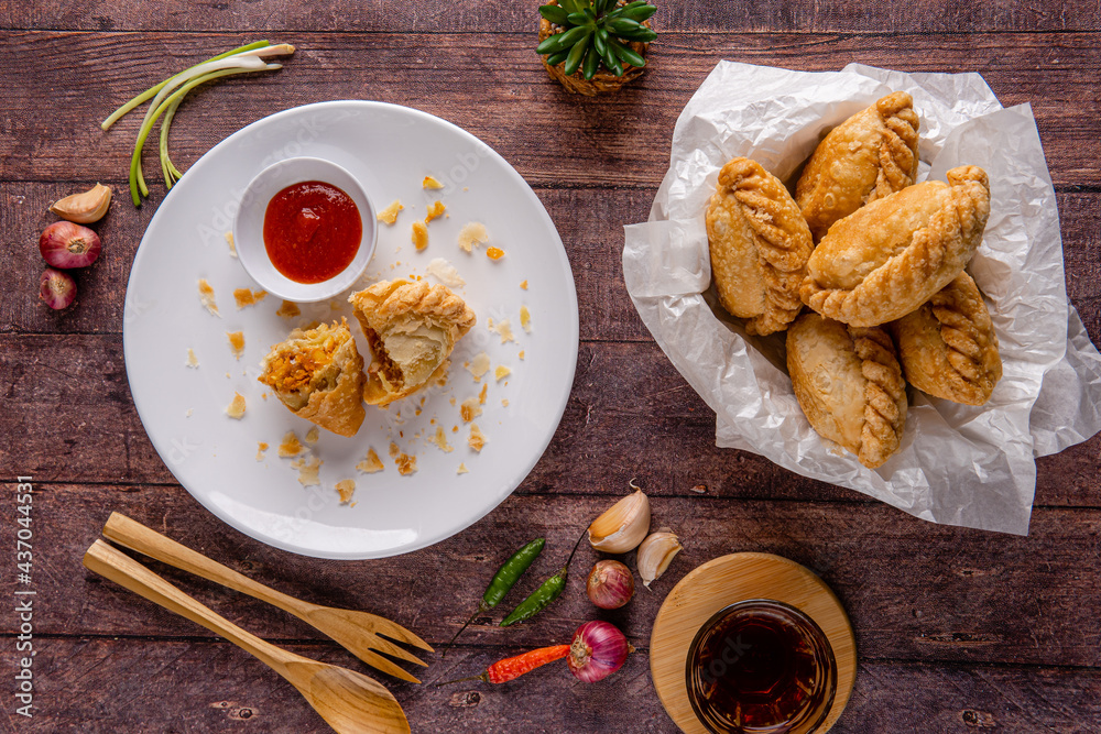 Curry puff or Pastel goreng. it is a small pie consisting of curry with chicken and potatoes in a deep-fried or baked pastry shell. The curry is quite thick to prevent it from oozing out of the snack