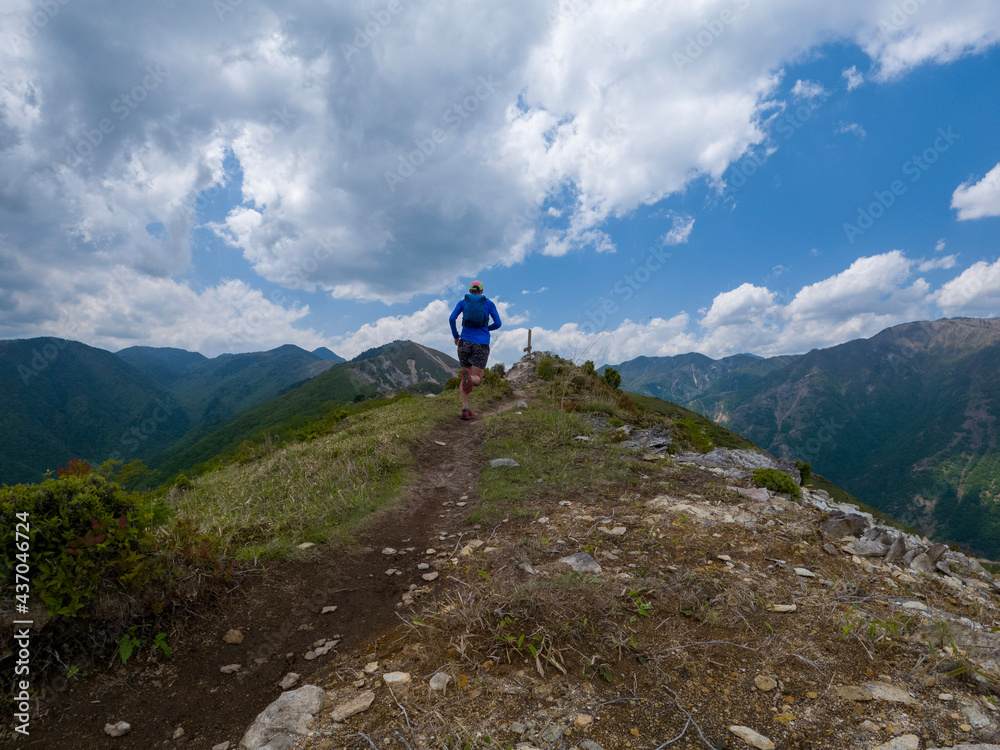 Runner on mountain ridge trail