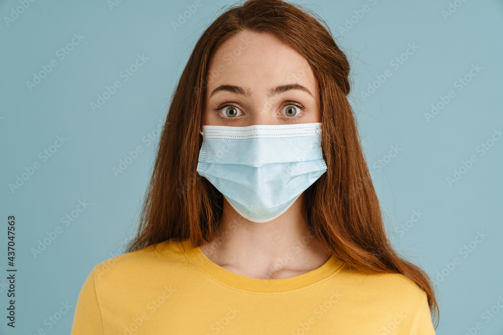 Young ginger white woman in face mask expressing surprise at camera Young ginger white woman in face mask expressing surprise at camera