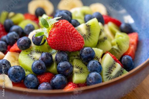 Fresh colorful fruit salad strawberry blueberry kiwi. Image with selective focus