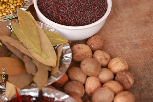 spices and herbs on kitchen or wooden table,Colorful spices and herbs for cooking with rotation teblet, Jaiphal, Star Anise, Chakri fool, Cardamom, Elaichi, Saunf,background rotating, photo