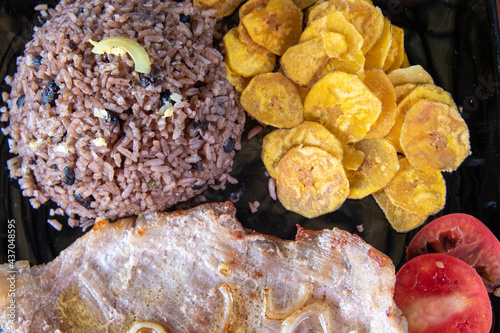 Photography Cuban traditional cuisine, pork steak, banana fries, and congri rice