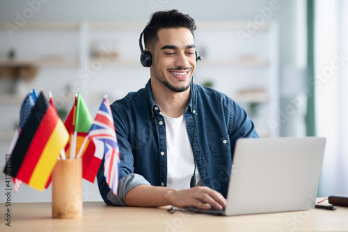 Happy arab guy student learning foreign language online