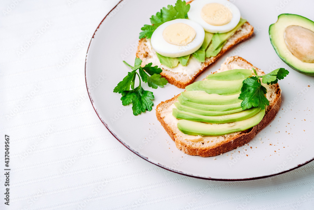 Toast with avocado and egg on white plate. Top view. Healthy breakfast