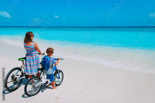 Happy mother and son biking at beach