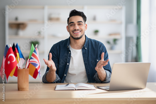 Positive arab guy foreign language teacher having conversation with student photo
