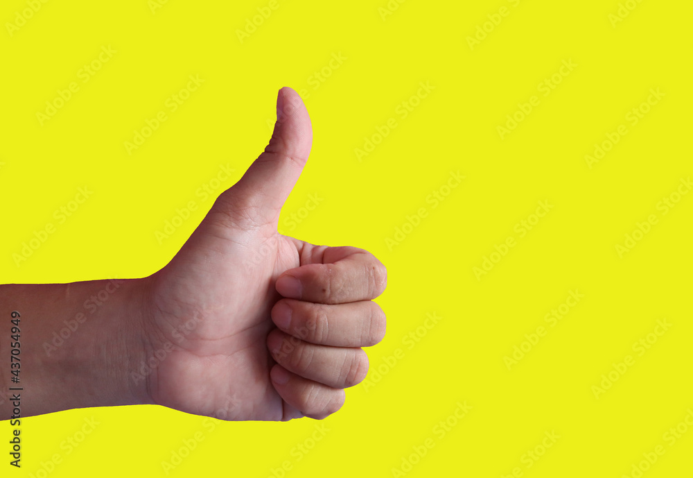 The hand sign says great. of the thumb pointing upwards on a yellow background