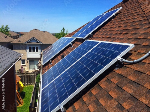Side view at solar panels on residential roof in Ontario, Canada. Production of solar panels. Green energy concept.