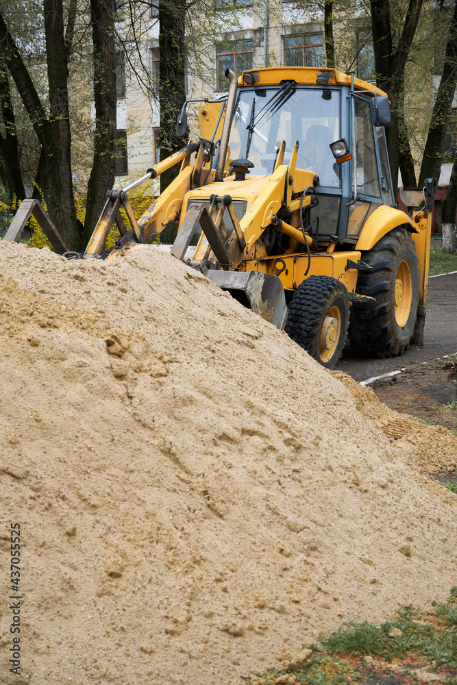 Obraz premium tractor or bulldozer works with a pile of sand for construction